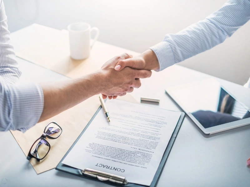 Two men shaking hands over a contract. Trust benefits, advantage of a trust, benefits of having a trust.