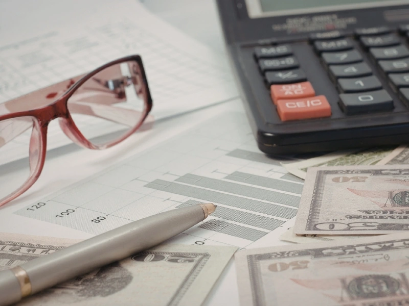 Glasses, calculator and financial chart highlighting the importance of general ledger.