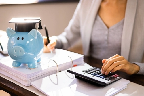 A woman works at her desk to identify student loan interest deductions