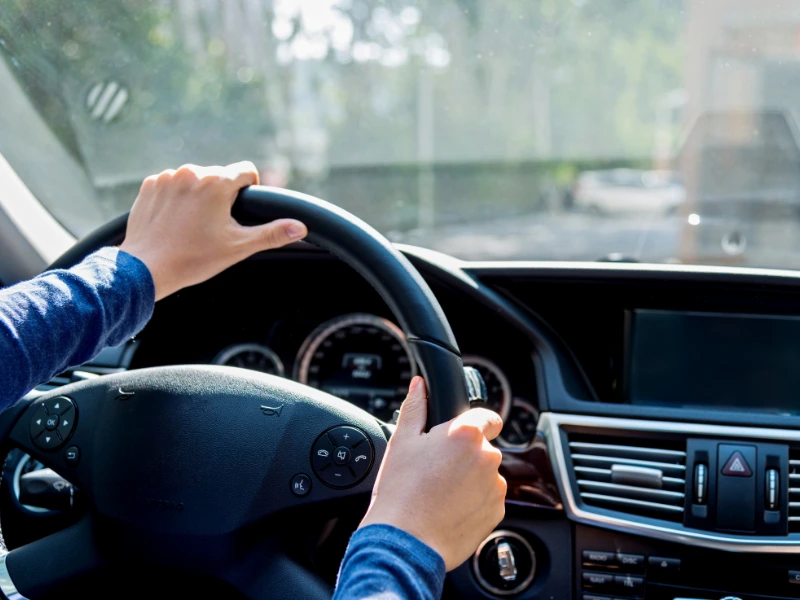 Hands on steering wheel. Image complements an article regarding 2026 irs standard mileage rate business