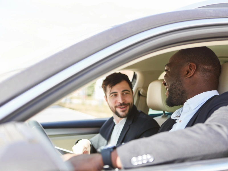 two business men in a car. image complements the post about the IRS business mileage rate.