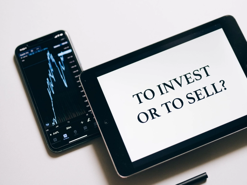 Flat lay of a tablet and smartphone displaying financial data, showing tax planning on investment gains.